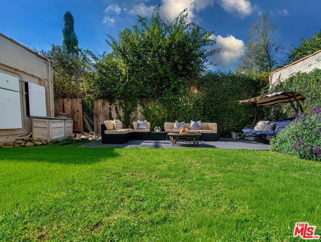 a view of a backyard with lawn chairs and a slide