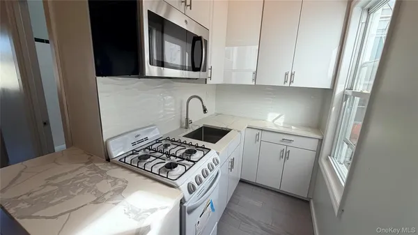 a kitchen with white cabinets and appliances