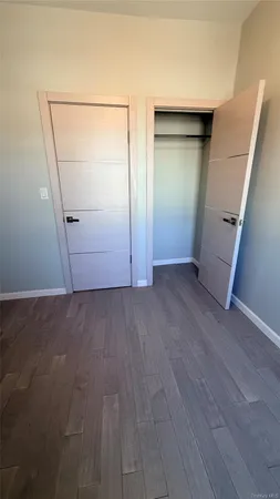 an empty room with wooden floor and entrance