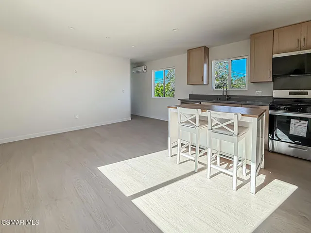 a kitchen with a dining table chairs and refrigerator