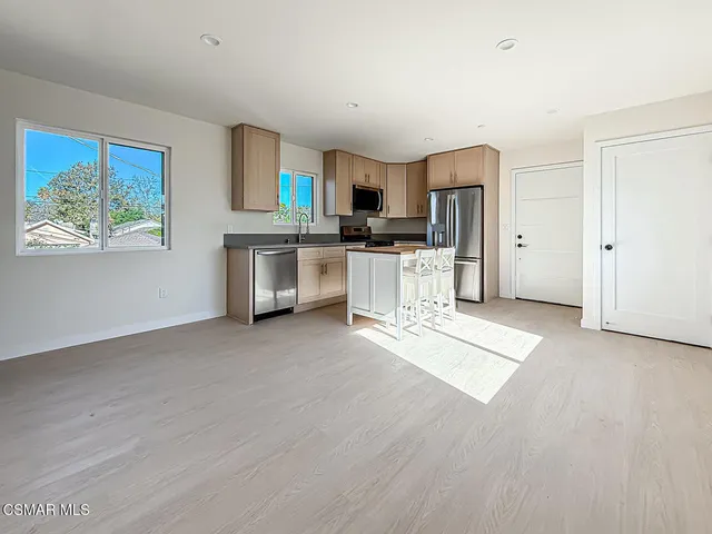 a kitchen with stainless steel appliances a refrigerator and a stove top oven