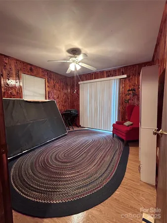 a view of a livingroom with furniture a ceiling fan and wooden floor