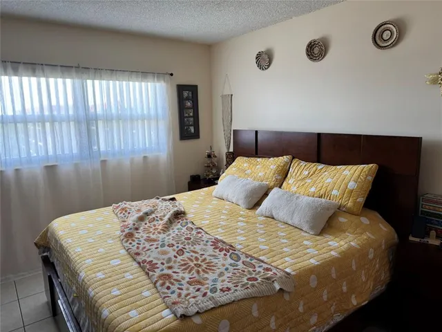 a large bed sitting in a bedroom next to a window and a larger closet