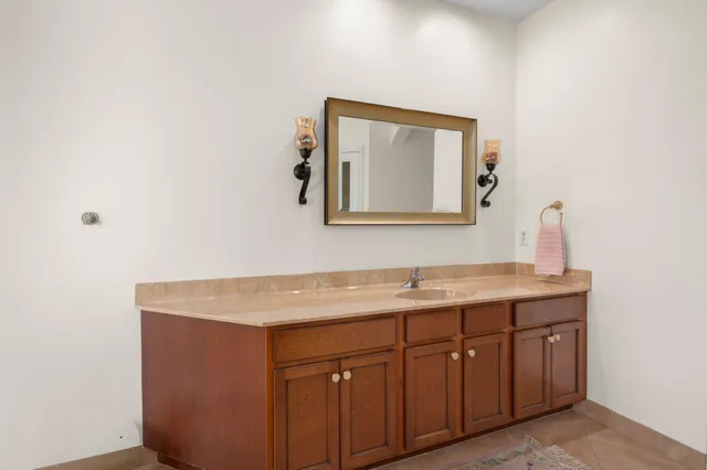 a spacious bathroom with a tub sink and mirror