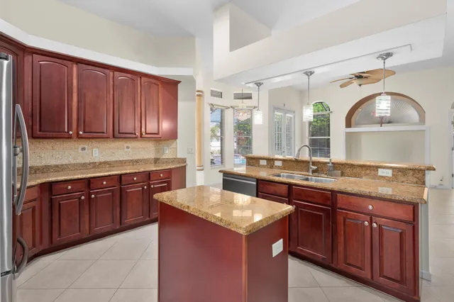 a kitchen with stainless steel appliances granite countertop wooden cabinets a stove a sink and dishwasher