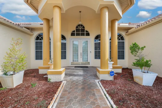 a front view of a house with plants