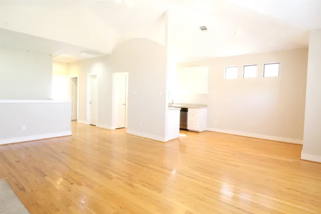 a view of empty room with wooden floor