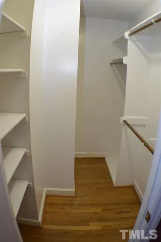 a view of walk in closet with wooden floor