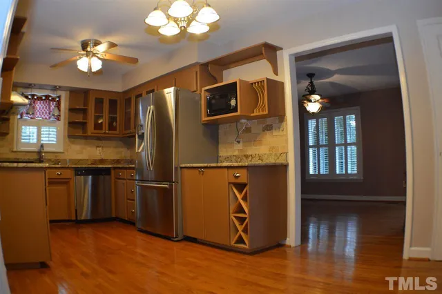 a kitchen with stainless steel appliances granite countertop a refrigerator and a sink