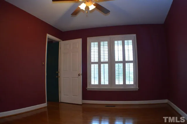 a room with wooden floor and a ceiling fan