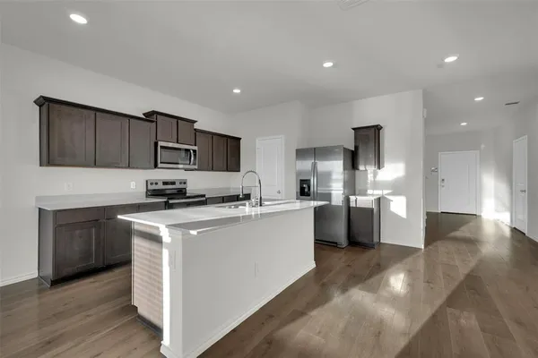a kitchen with a sink a counter top space stainless steel appliances and cabinets