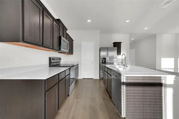 a kitchen with stainless steel appliances granite countertop a sink stove and cabinets