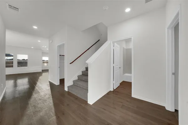 a view of a hallway with wooden floor and staircase