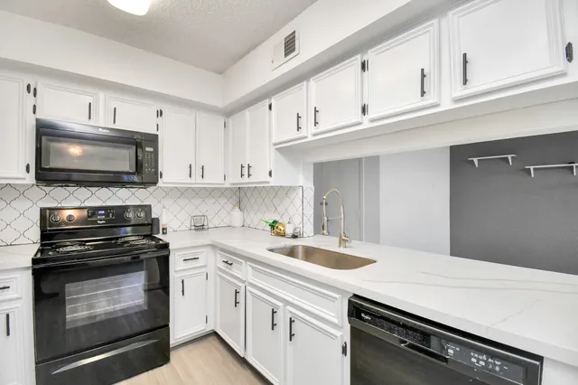 a kitchen with cabinets appliances a sink and a counter top