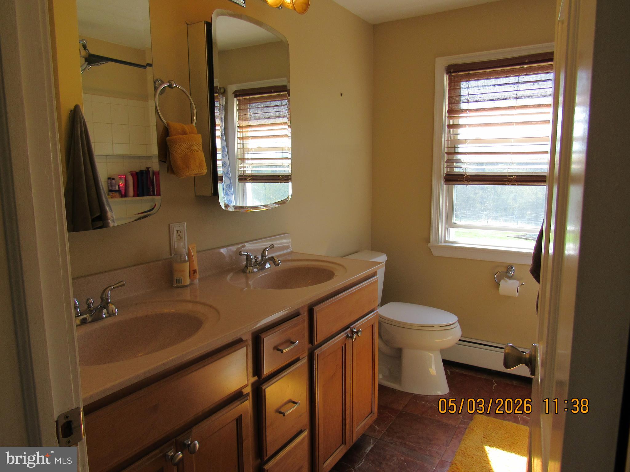 1276 Stump Hall Road Collegeville, PA 19426 - Photo 8 of 46 a bathroom with a sink a toilet a mirror and window