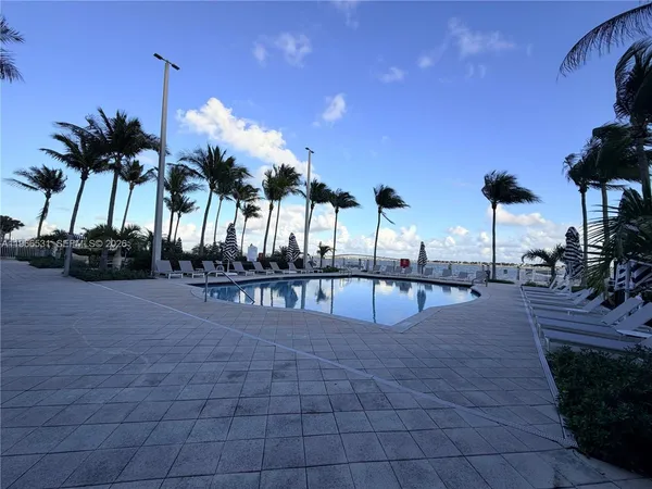a front view of multi story residential apartment building with yard and seating space