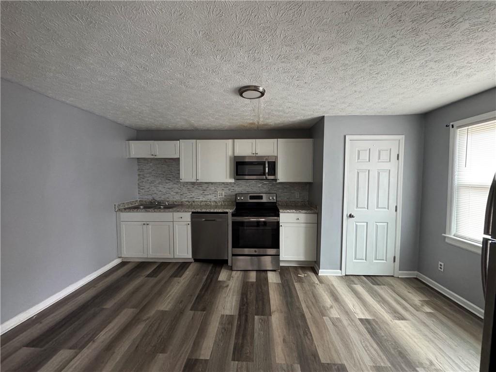 1410 Cave Spring Road Southwest Rome, GA 30161 - Photo 6 of 13 a kitchen with granite countertop a sink cabinets and stainless steel appliances