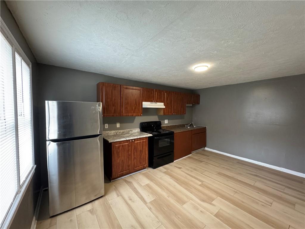 1410 Cave Spring Road Southwest Rome, GA 30161 - Photo 9 of 13 a kitchen with a refrigerator and a stove top oven