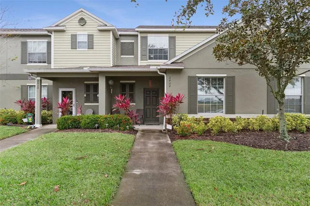 a front view of a house with a yard and potted plants