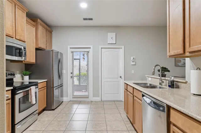 a kitchen with stainless steel appliances granite countertop a sink stove and refrigerator