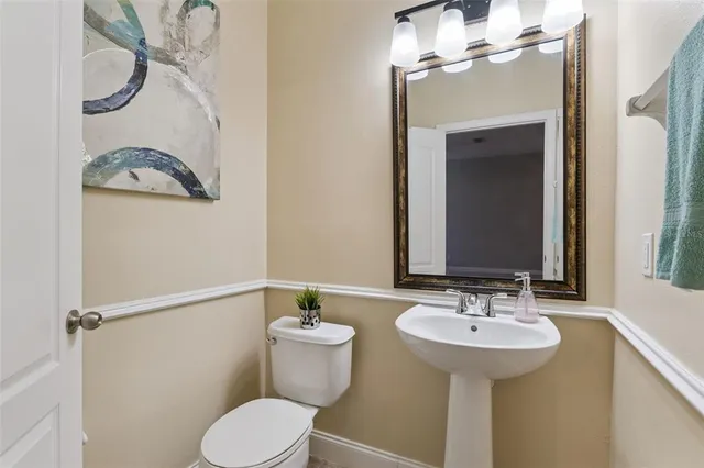 a bathroom with a sink mirror and toilet