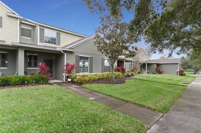 a front view of a house with a yard and trees