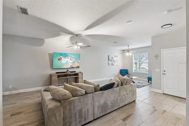 a living room with furniture and a wooden floor