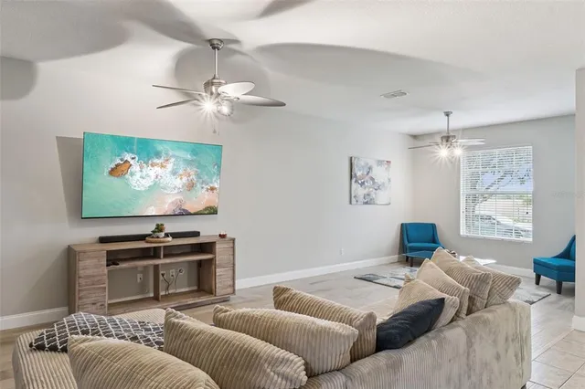 a living room with furniture a ceiling fan and a window