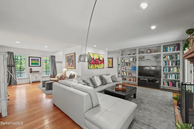 a living room with furniture a flat screen tv and a rug