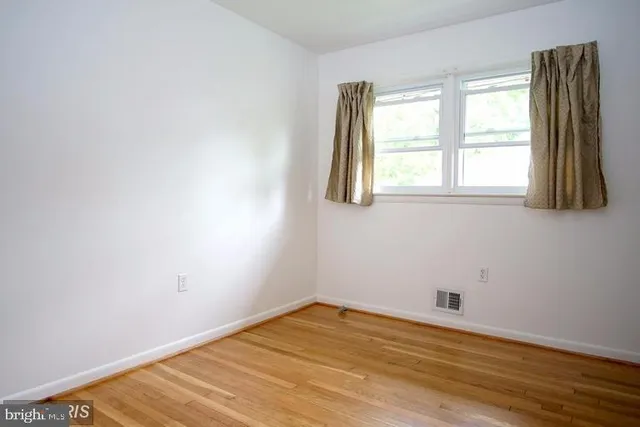 a view of a room with wooden floor and a window