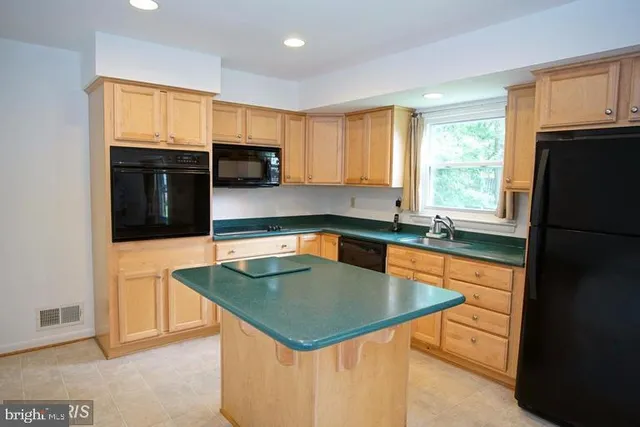 a kitchen with stainless steel appliances granite countertop a sink a stove and refrigerator