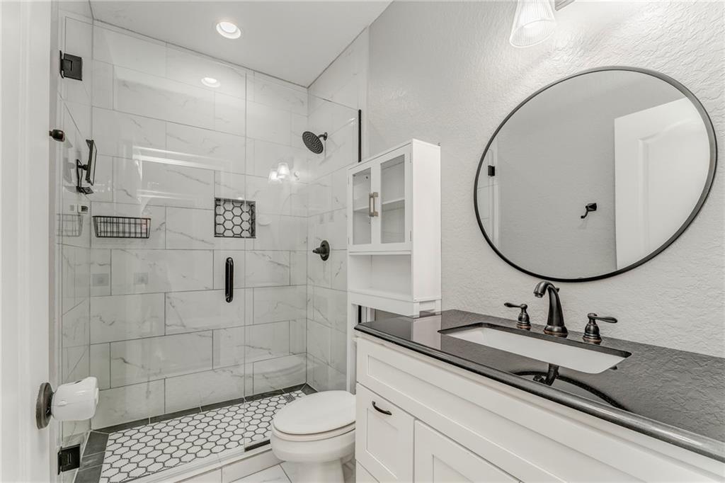 311 Langston Road Southeast Calhoun, GA 30701 - Photo 47 of 100 a bathroom with a sink toilet a mirror and shower