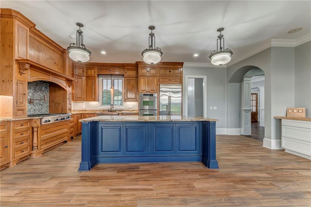 311 Langston Road Southeast Calhoun, GA 30701 - Photo 99 of 100 a large kitchen with granite countertop a stove a sink dishwasher a dining table and chairs with wooden floor
