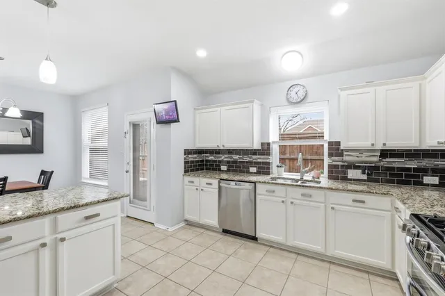 a kitchen with white cabinets and appliances