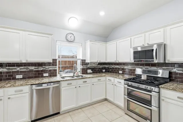 a kitchen with stainless steel appliances granite countertop a sink and cabinets