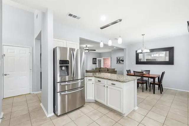 a kitchen with stainless steel appliances granite countertop a stove refrigerator and dining table
