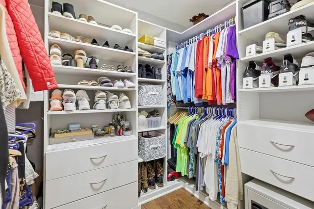 a view of walk in closet with clothes and shoes