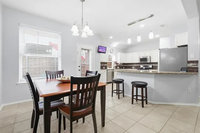 a view of a dining room with furniture and chandelier