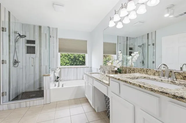a bathroom with a granite countertop sink a large mirror a shower and a bathtub