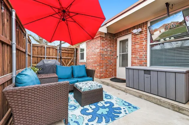 a view of a patio with couches table and chairs under an umbrella