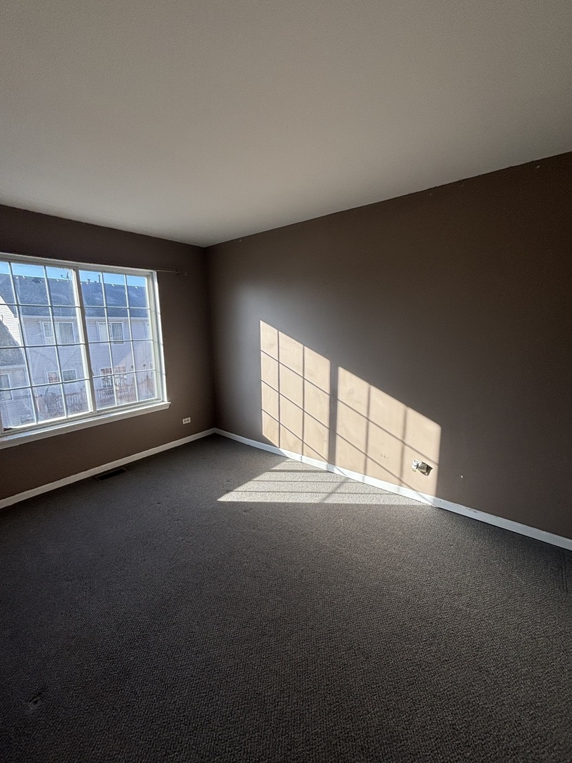 647 Georgian Court, Unit 647 Addison, IL 60101 - Photo 11 of 12 an empty room with a empty space and windows