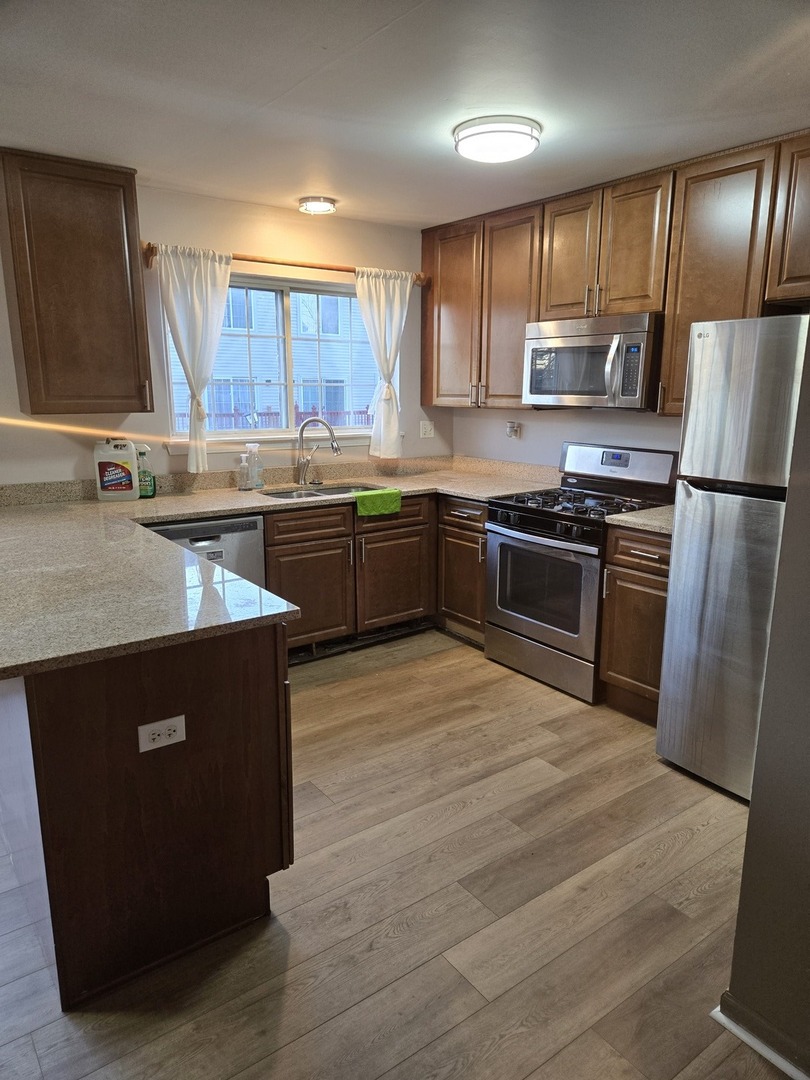 647 Georgian Court, Unit 647 Addison, IL 60101 - Photo 3 of 12 a kitchen with stainless steel appliances granite countertop a stove a sink dishwasher a refrigerator and a oven