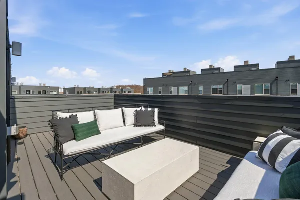 a view of a roof deck with couches and wooden floor