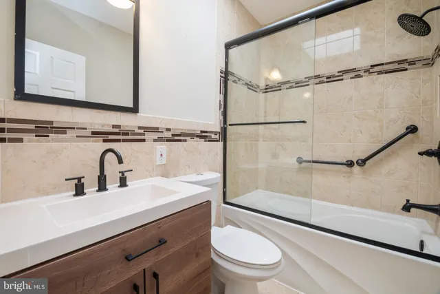 a bathroom with a sink mirror vanity and toilet