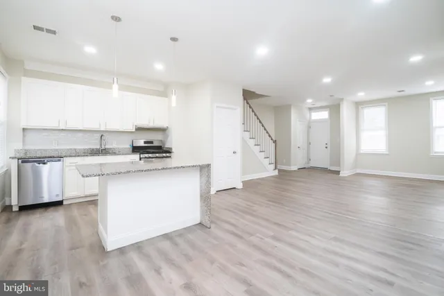 a kitchen with a white wooden cabinets and window
