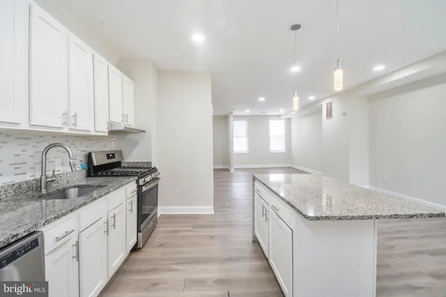 a kitchen with stainless steel appliances granite countertop a sink stove and cabinets