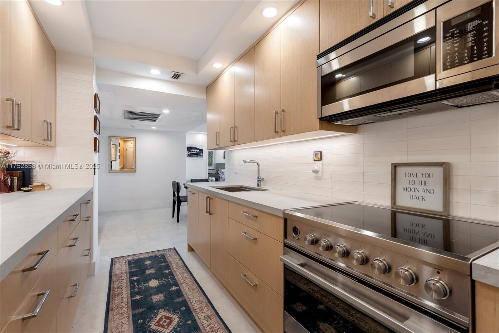 5401 Collins Avenue, Unit 1220 Miami Beach, FL 33140 - Photo 6 of 13 a kitchen with a stove and a sink