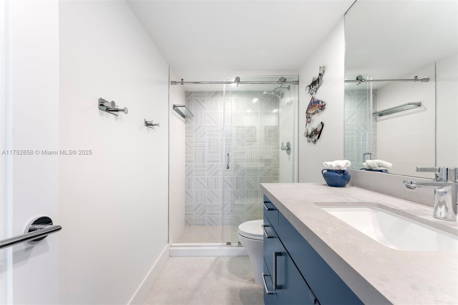 5401 Collins Avenue, Unit 1220 Miami Beach, FL 33140 - Photo 8 of 13 a bathroom with a sink a toilet and shower