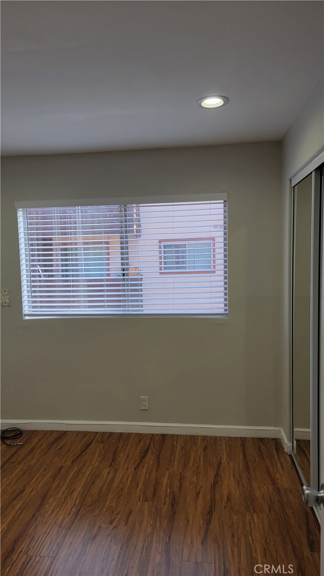 5403 Newcastle Avenue, Unit 12 Encino, CA 91316 - Photo 17 of 26 a view of an empty room with wooden floor and a window