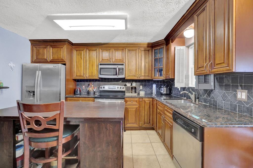 1555 Rock Springs Road Buford, GA 30519 - Photo 8 of 27 a kitchen with stainless steel appliances granite countertop a stove a sink and a microwave